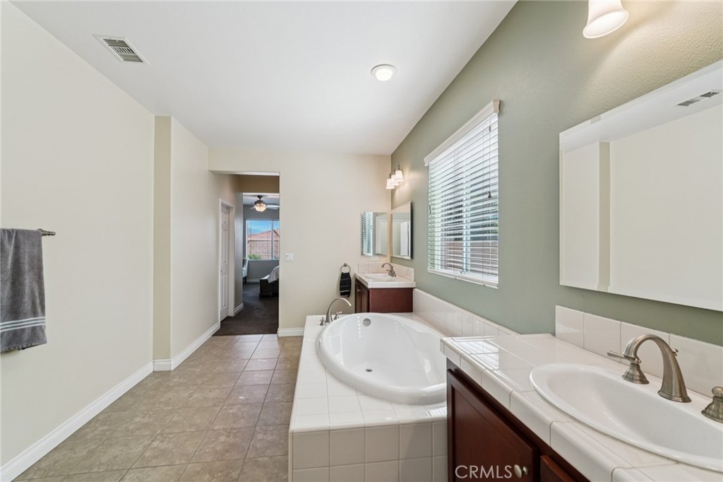 28552 Rustic Glen Street Menifee, CA 92584 - Photo 22 of 48 Primary bathroom with dual sinks and a large soaking tub