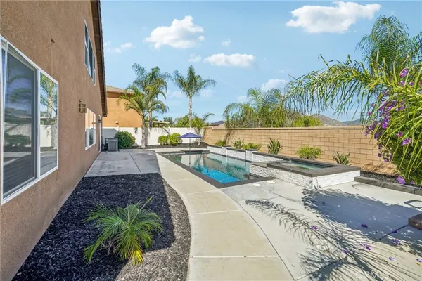 a view of a swimming pool with a patio and a yard