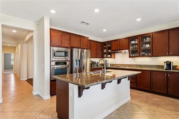 a kitchen with stainless steel appliances granite countertop a refrigerator a sink and a stove