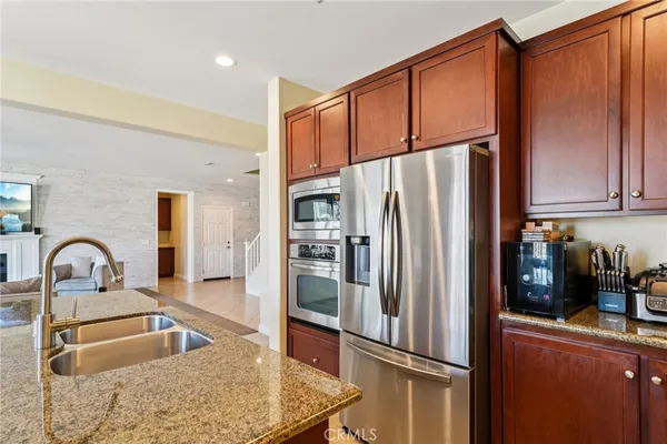 a kitchen with stainless steel appliances granite countertop a refrigerator and a sink