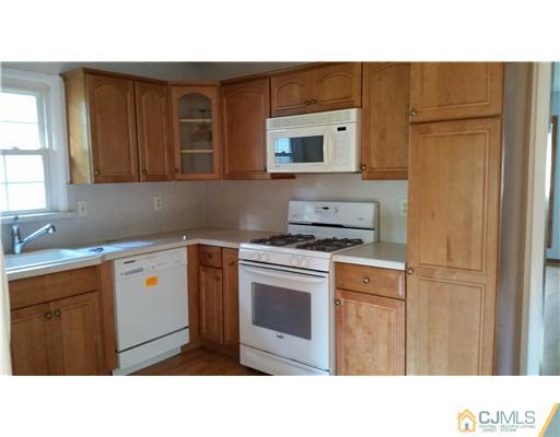626 Spruce Road North Brunswick, NJ 08902 - Photo 3 of 23 a kitchen with a stove a sink and a microwave