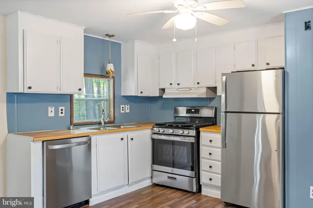 a kitchen with stainless steel appliances a stove a refrigerator and a sink