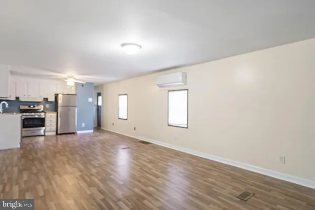a view of a kitchen with furniture and wooden floor
