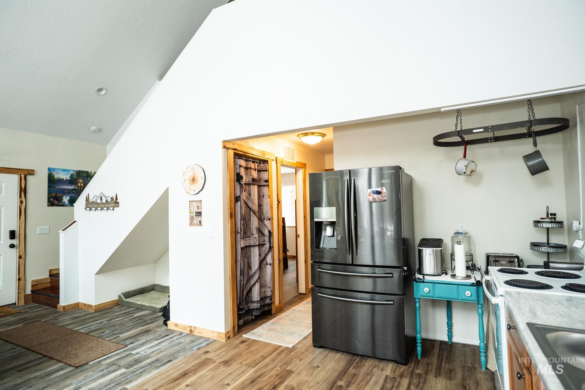 22 West Prospectors Drive Cascade, ID 83611 - Photo 23 of 29 Kitchen with refrigerator with ice dispenser, electric range, lofted ceiling, dark wood-style flooring, and light countertops