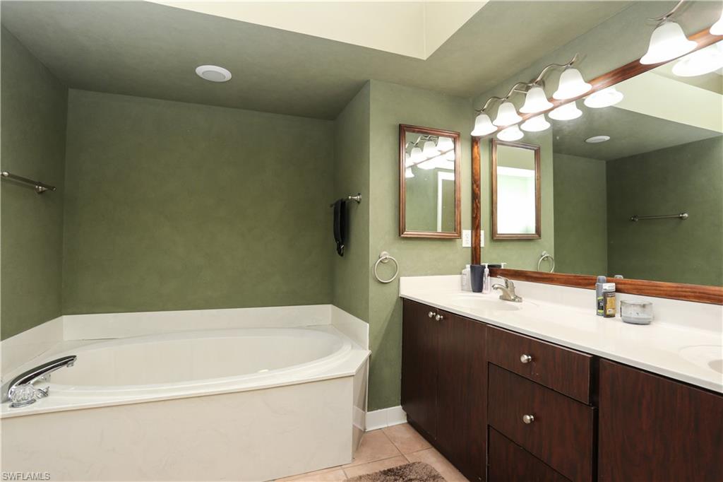162 Eveningstar Cay Naples, FL 34114 - Photo 15 of 32 a bathroom with a tub sink and mirror