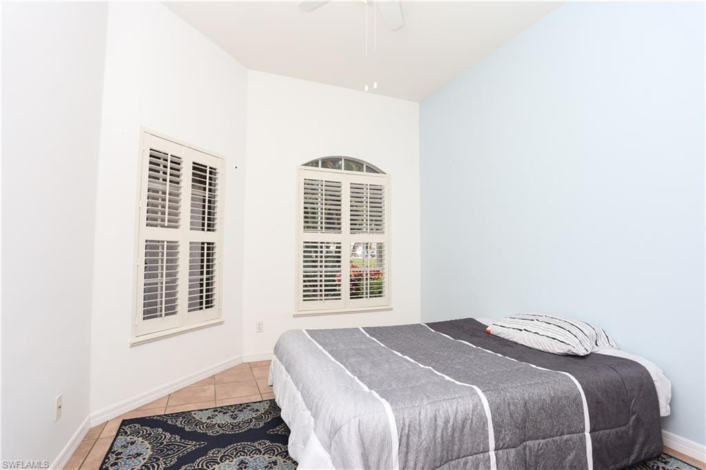 162 Eveningstar Cay Naples, FL 34114 - Photo 17 of 32 a bedroom with a bed and a window