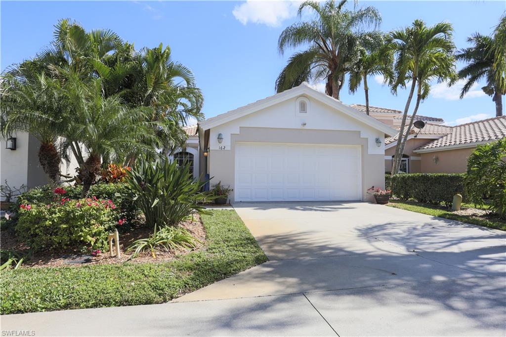 162 Eveningstar Cay Naples, FL 34114 - Photo 3 of 32 a front view of a house with a yard and garage
