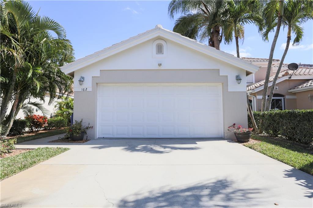 162 Eveningstar Cay Naples, FL 34114 - Photo 4 of 32 a front view of a house with a yard