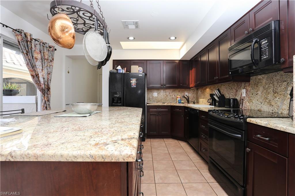 162 Eveningstar Cay Naples, FL 34114 - Photo 8 of 32 a kitchen with stainless steel appliances granite countertop a stove a sink and a microwave oven with cabinets