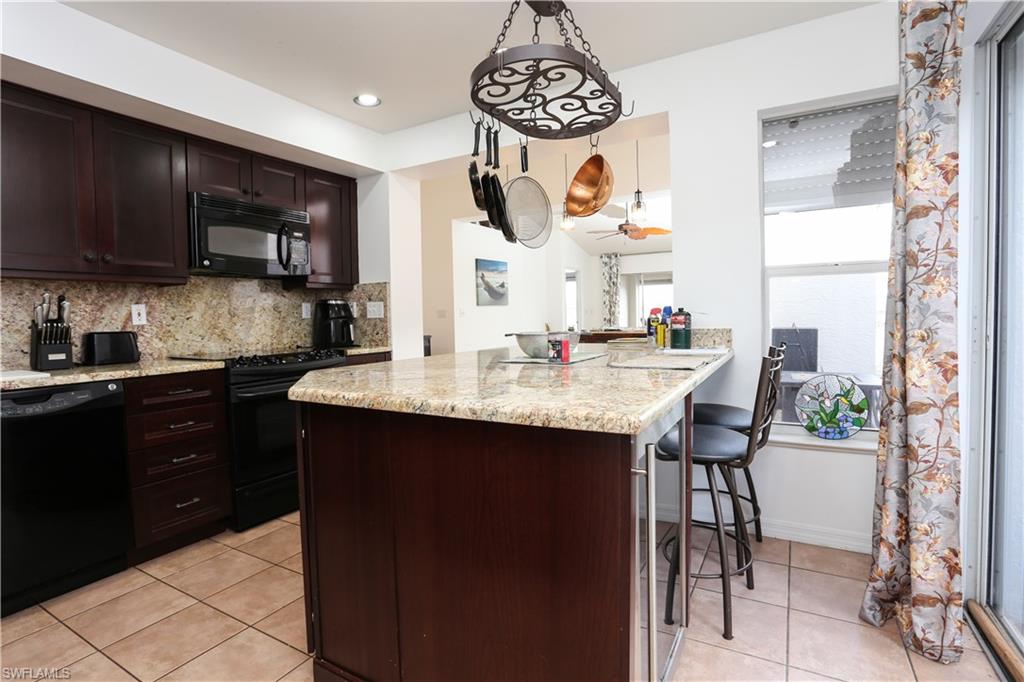 162 Eveningstar Cay Naples, FL 34114 - Photo 9 of 32 a kitchen with stainless steel appliances granite countertop a sink and a stove