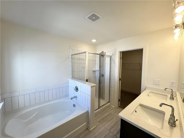 a bathroom with a tub sink and mirror