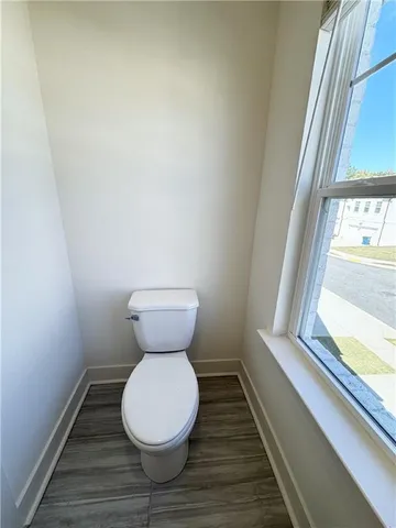 a bathroom with a toilet and a window