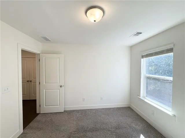 an empty room with windows and closet