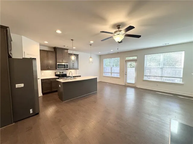 a kitchen with kitchen island a counter top space stainless steel appliances and a window