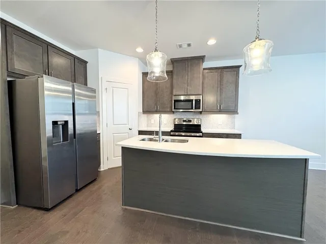 a kitchen with kitchen island a sink appliances and cabinets