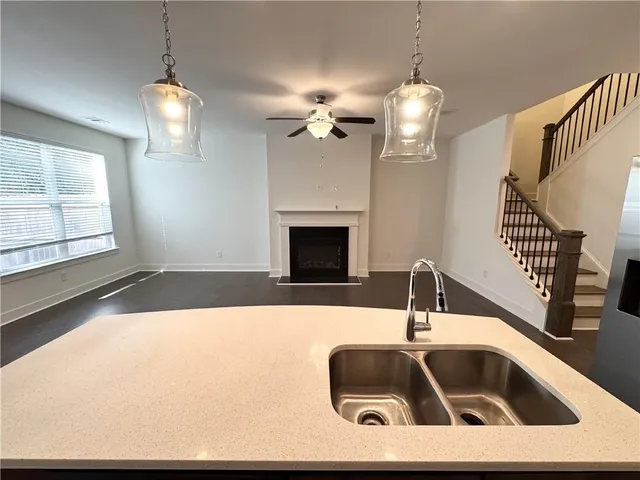 a kitchen with a sink a chandelier and fireplace