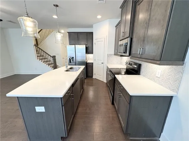 a kitchen with a sink a refrigerator and wooden floor