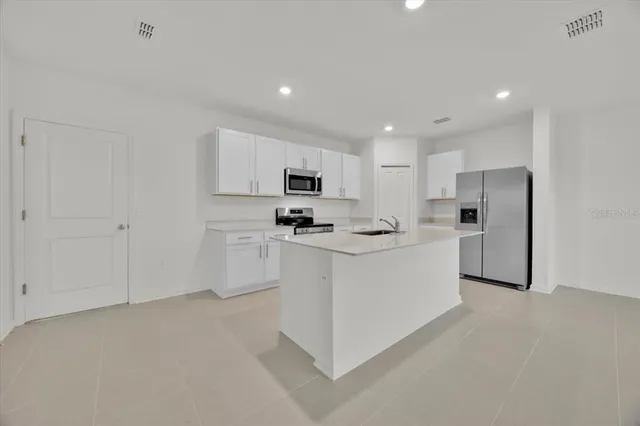 a kitchen with white cabinets and stainless steel appliances