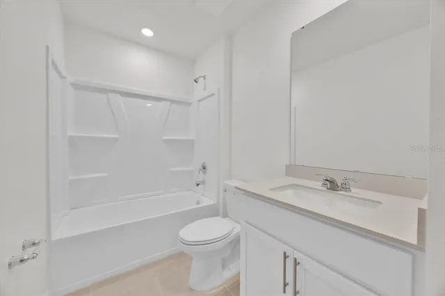 a bathroom with a bathtub shower sink vanity and toilet