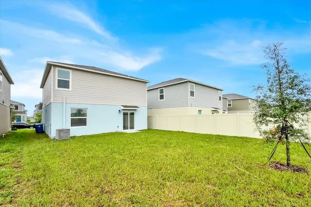 a front view of house with yard and trees in the background