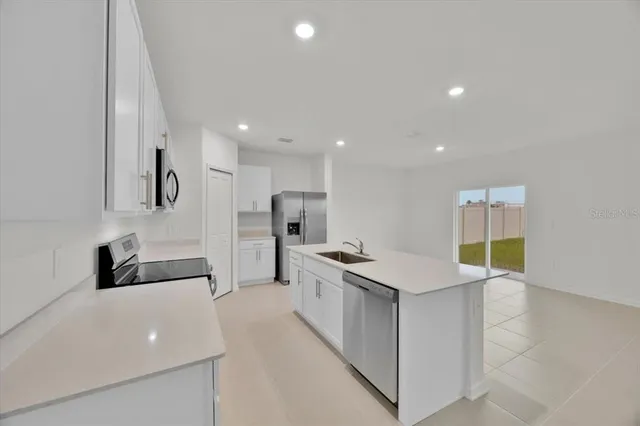 a kitchen with stainless steel appliances a sink stove and refrigerator