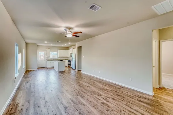 a view of large kitchen with wooden floor and a window