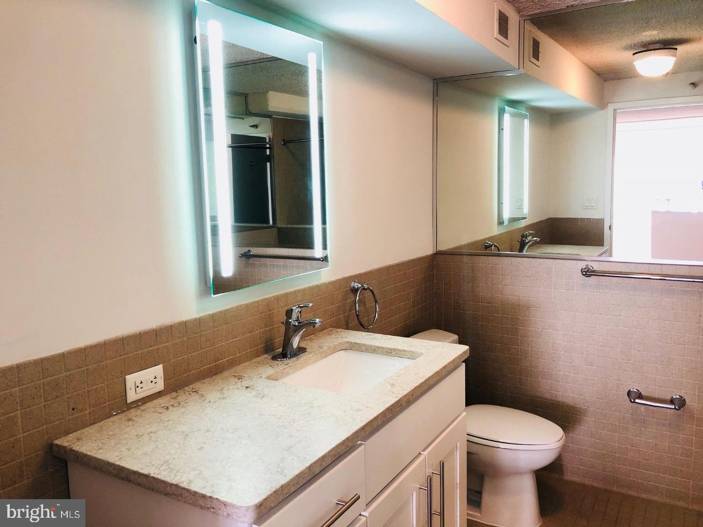 2300 Walnut Street, Unit 1B619 Philadelphia, PA 19103 - Photo 10 of 11 a bathroom with a sink a toilet and a mirror