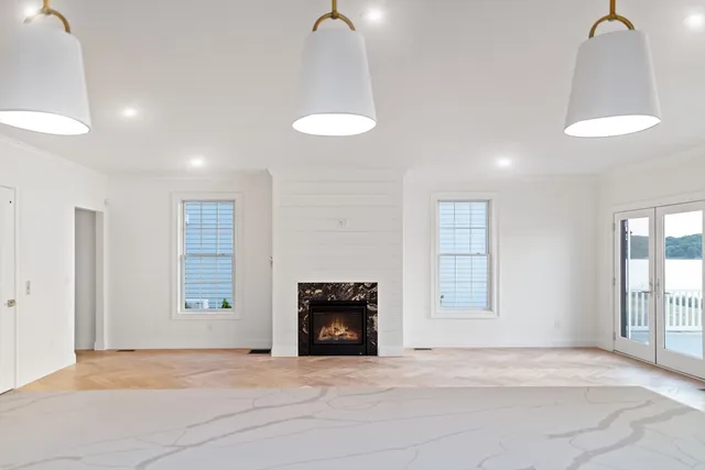 a view of an empty room with a fireplace and a window