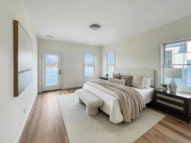 a spacious bedroom with a bed and wooden floor