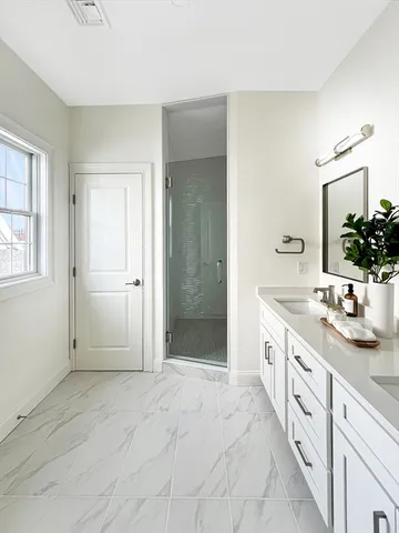 a spacious bathroom with a double vanity sink a large mirror a shower and a bathtub