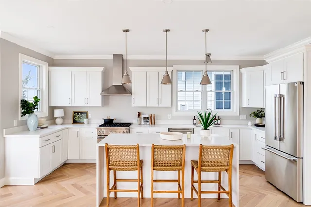 a kitchen with stainless steel appliances kitchen island granite countertop a table chairs and a refrigerator