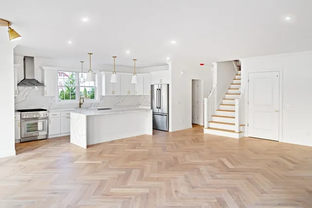 a kitchen with stainless steel appliances kitchen island granite countertop a stove a sink and a refrigerator