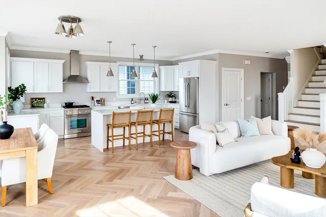 a living room with furniture white walls and kitchen view