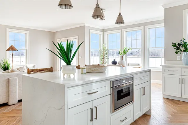 a kitchen with stainless steel appliances white cabinets and wooden floor