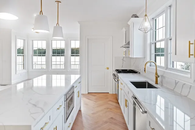 a kitchen with stainless steel appliances granite countertop a sink a stove and a wooden floors
