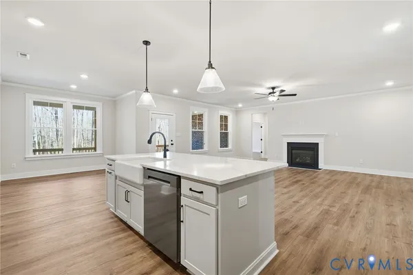 an empty room with wooden floor ceiling fan and windows