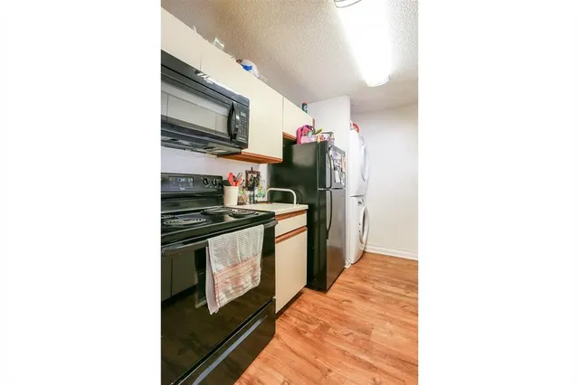 a kitchen with stainless steel appliances granite countertop a refrigerator and a stove