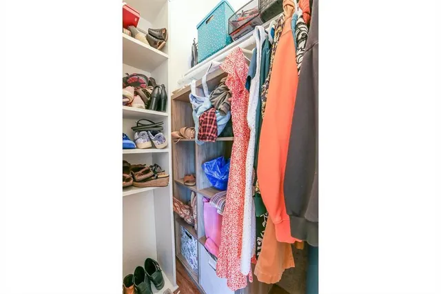 a view of walk in closet with clothes and shoes