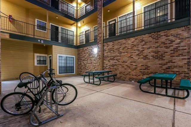 a view of a brick building with furniture and a bench