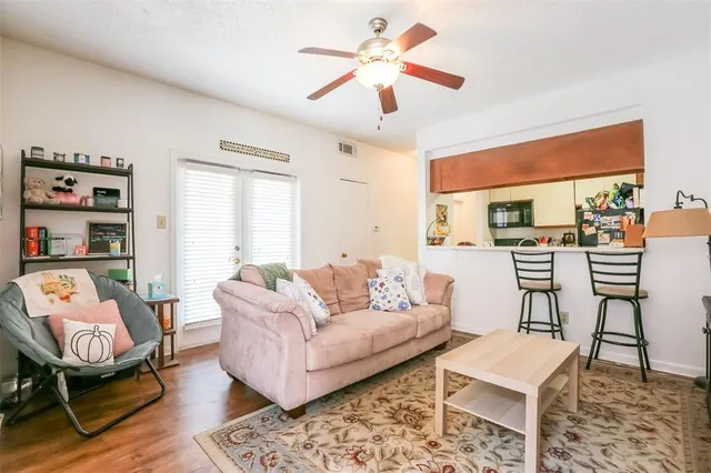 a living room with furniture a rug and a large window