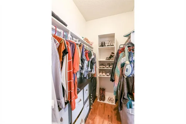 a view of walk in closet with clothes