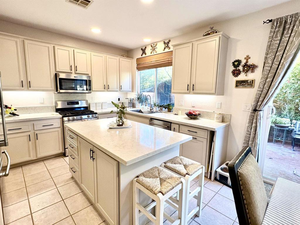 2879 Bear Valley Road Chula Vista, CA 91915 - Photo 14 of 61 a kitchen with a sink a stove cabinets and a dining table