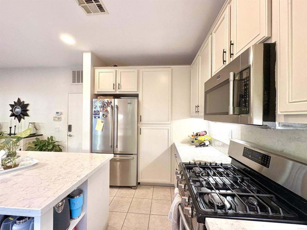 2879 Bear Valley Road Chula Vista, CA 91915 - Photo 19 of 61 a kitchen with stainless steel appliances granite countertop a sink stove and refrigerator