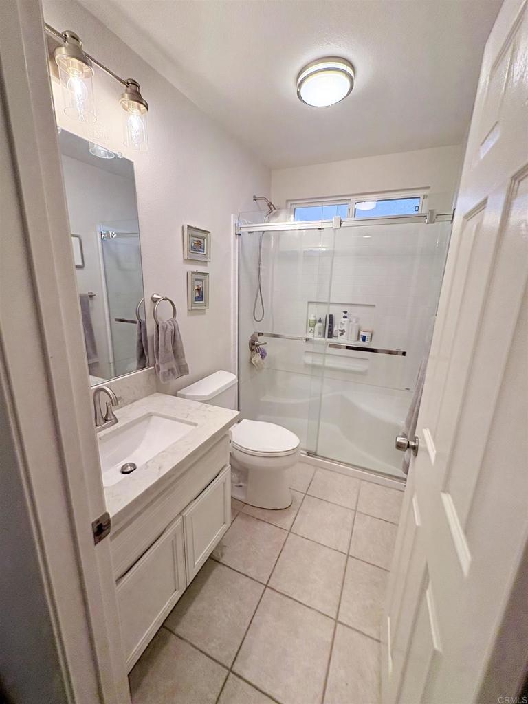 2879 Bear Valley Road Chula Vista, CA 91915 - Photo 31 of 61 a bathroom with a sink a toilet a mirror and shower