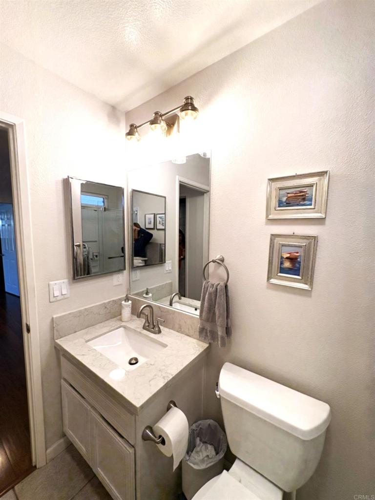 2879 Bear Valley Road Chula Vista, CA 91915 - Photo 34 of 61 a bathroom with a toilet a sink and mirror