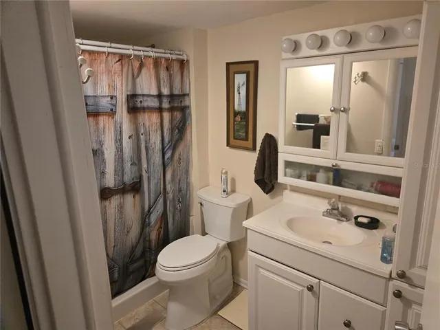 a bathroom with a sink a toilet a mirror and shower