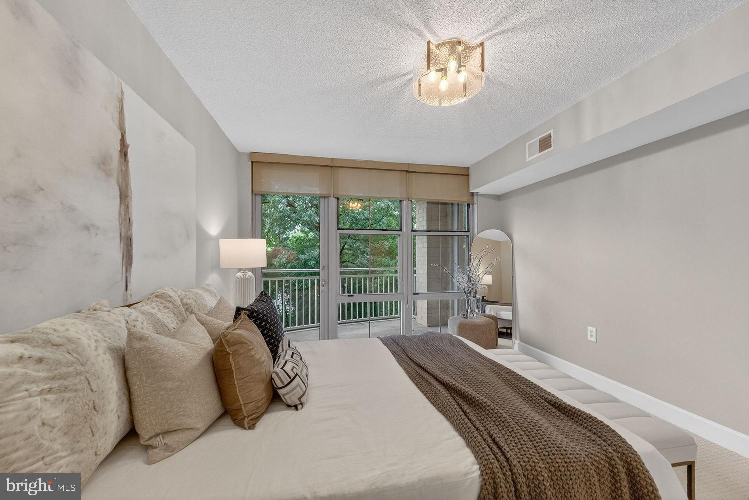11800 Sunset Hills Road, Unit 314 Reston, VA 20190 - Photo 15 of 50 a bedroom with a bed and a lamp with window