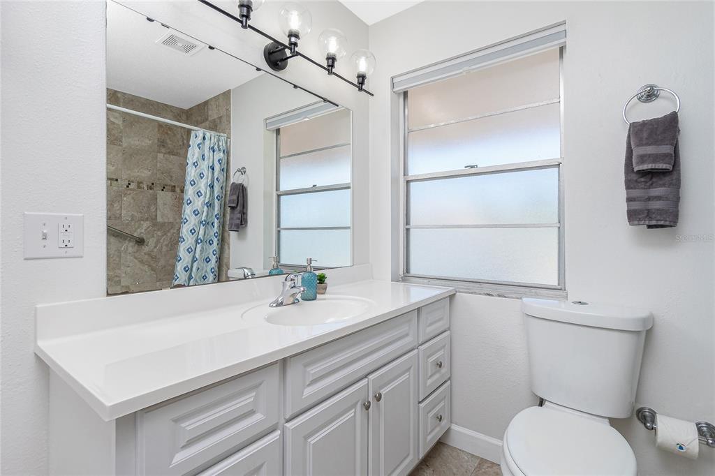 2375 North Beach Road, Unit 2B Englewood, FL 34223 - Photo 25 of 44 a bathroom with a sink toilet vanity and shower