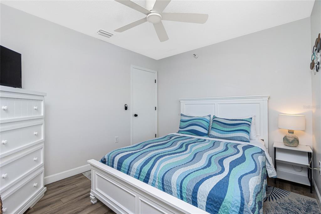2375 North Beach Road, Unit 2B Englewood, FL 34223 - Photo 27 of 44 a bedroom with a bed and flat screen tv