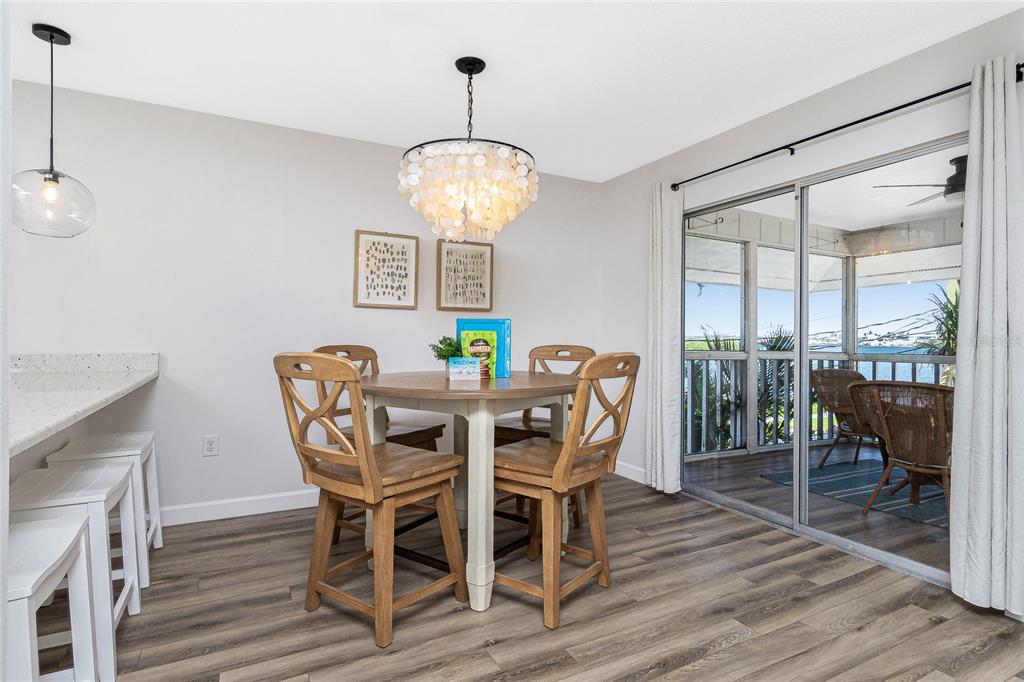 2375 North Beach Road, Unit 2B Englewood, FL 34223 - Photo 10 of 44 a view of a dining room with furniture wooden floor and chandelier
